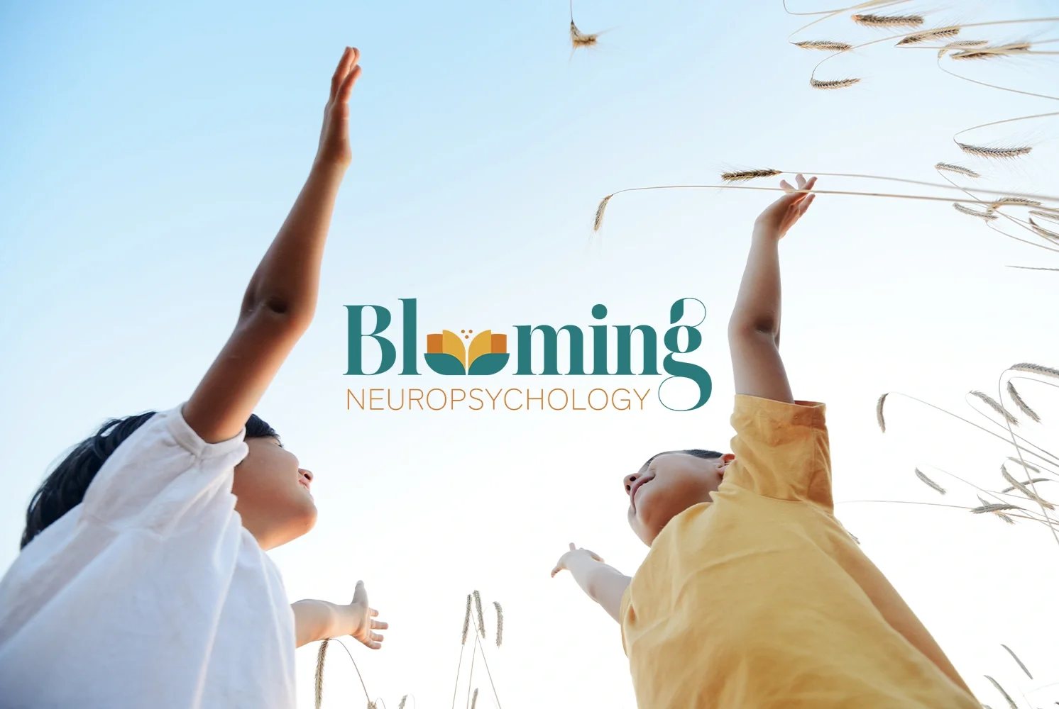 Two children reaching up towards the sky amidst tall grass, with the words 'Blooming Neuropsychology' overlaid.