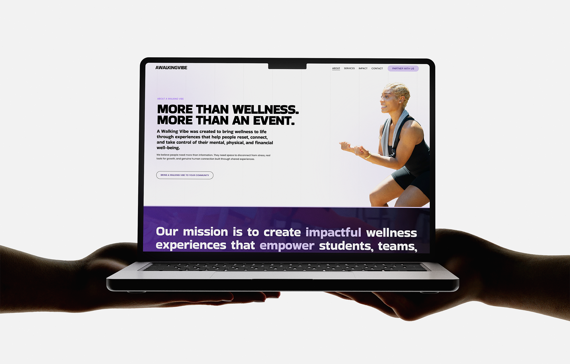 Hands holding a laptop with a website open on the screen, featuring a woman with short blonde hair smiling, in black athletic wear, and text about wellness experiences.