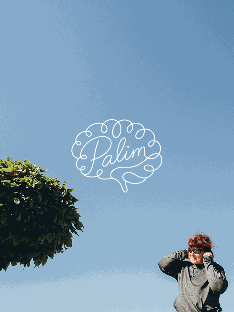 A woman wearing sunglasses and a gray jacket smiling outdoors against a clear blue sky with the word "Palma" written in cursive inside a speech bubble shape.