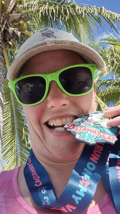 Carrie Findlay with her Castaway Cay 5K medal on Disney's Castaway Cay