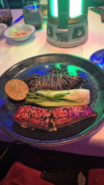 The Tamari and Honey-Glazed Salmon with Bok Choy and Squid Ink Pasta at Worlds of Marvel on the Disney Treasure