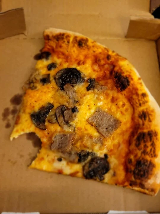 enjoying pizza from the Pizza Window on Disney's Boardwalk