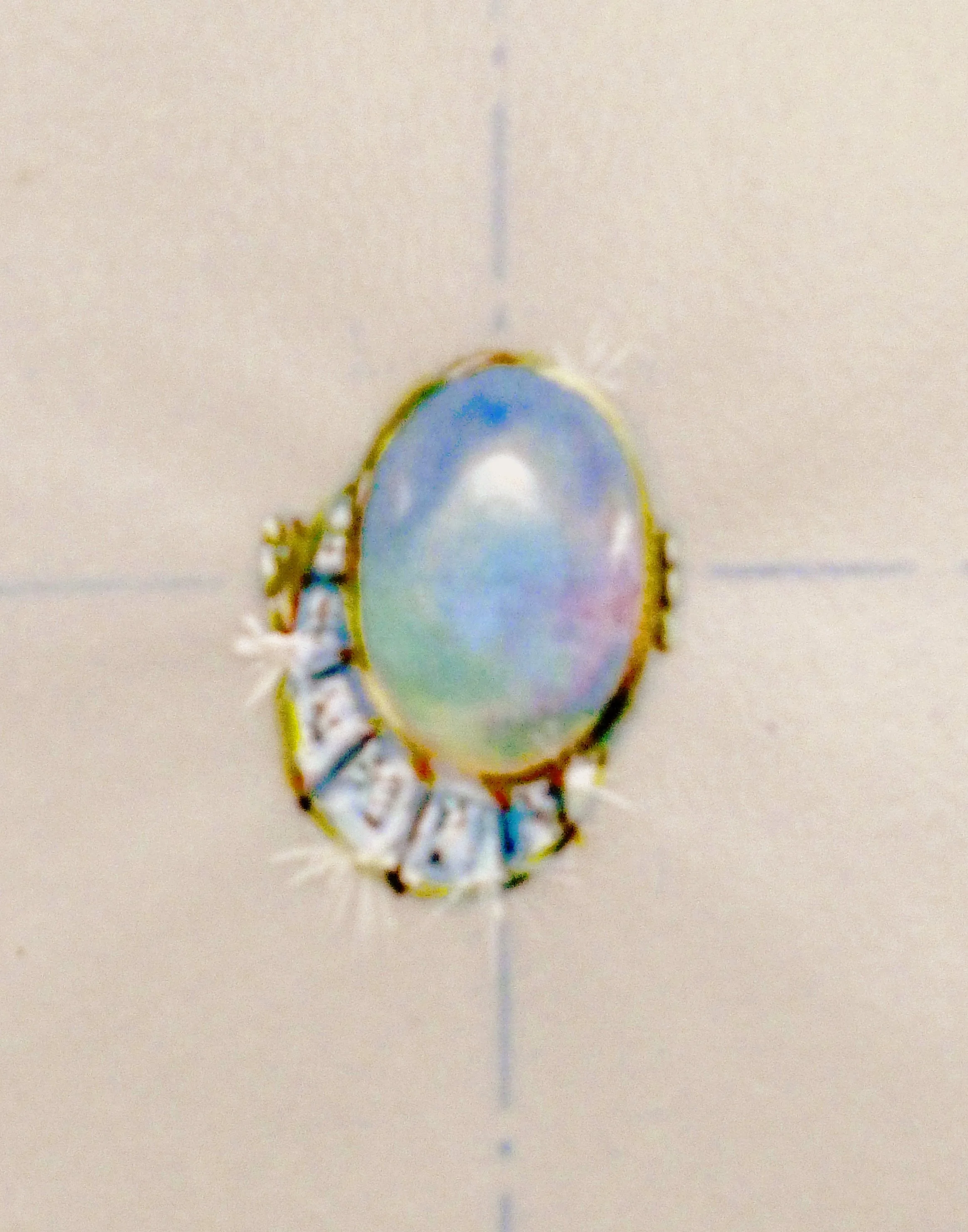 Une bague en croissant de lune de diamants épousant une opale de feu ovale