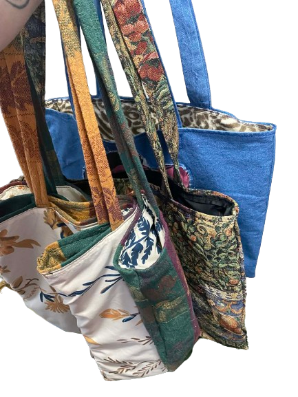 Various tote bags made from thrifted materials. 