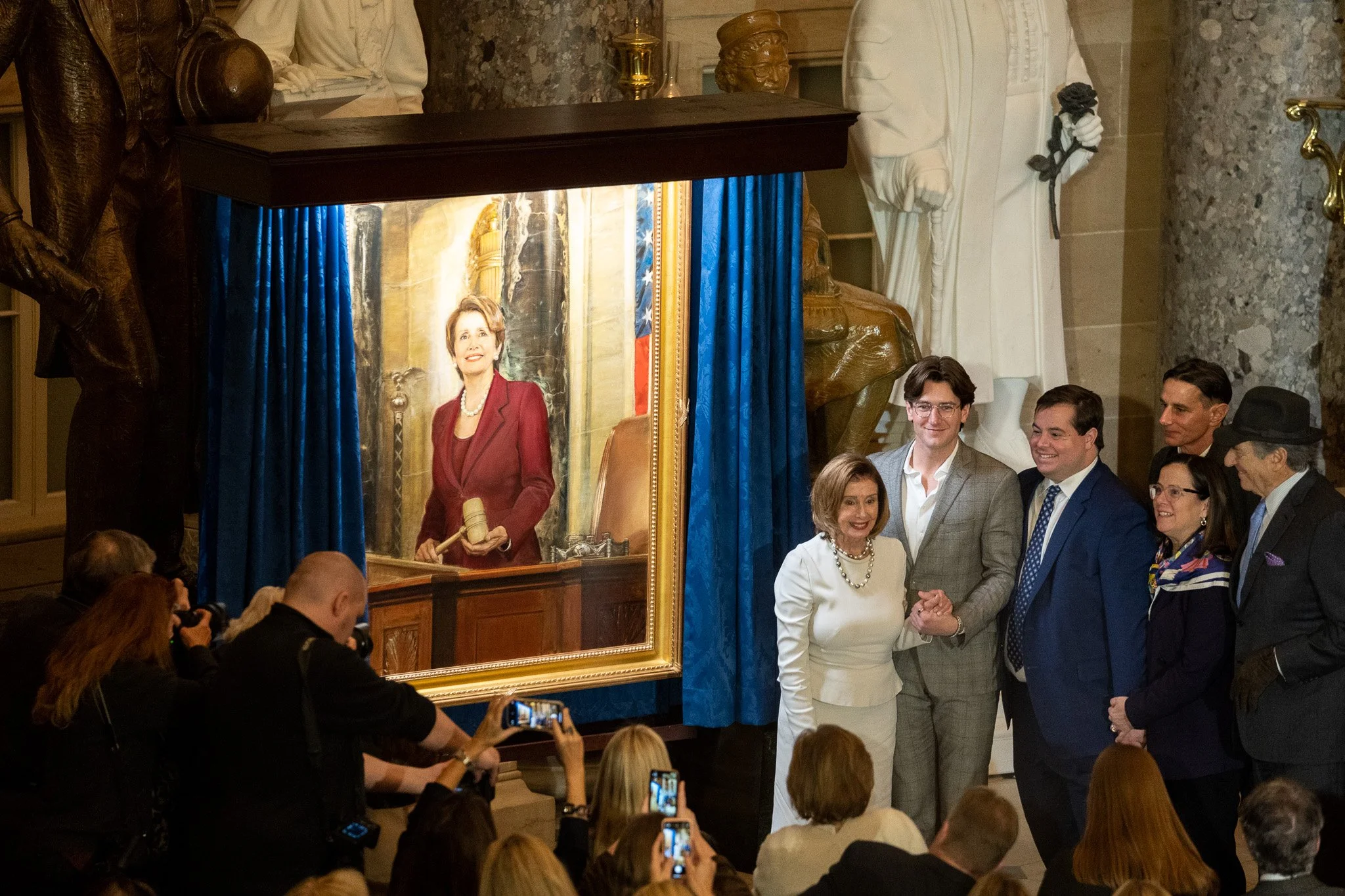 Speaker Emerita Nancy Pelosi stands with her family in front of her recently unveiled portrait in Statuary Hall.