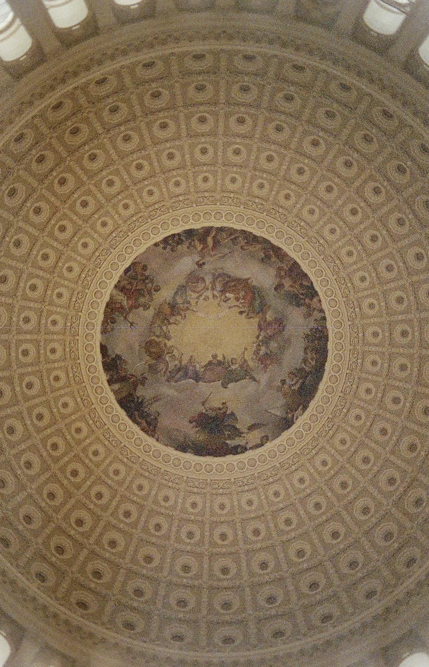 Ceiling with decorative patterns and a painted scene in the center, likely from a historic building.
