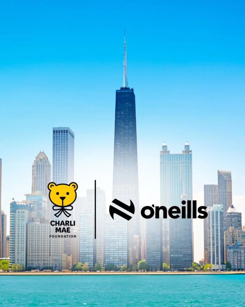 A city skyline featuring tall skyscrapers, including the One World Trade Center, with a body of water in the foreground and three logos at the bottom for Charli Mae Foundation and O'neills.
