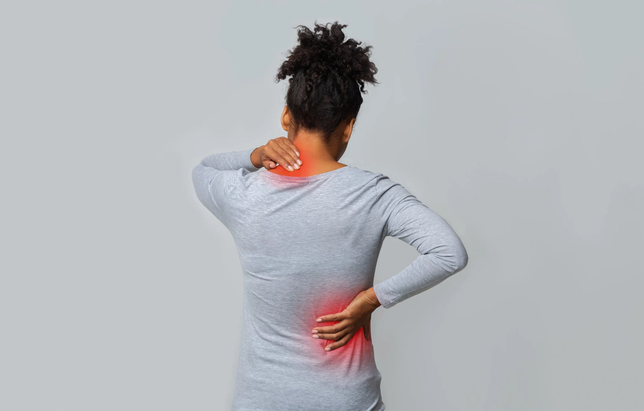 a woman is shown from behind holding sore spots on her neck and lower back