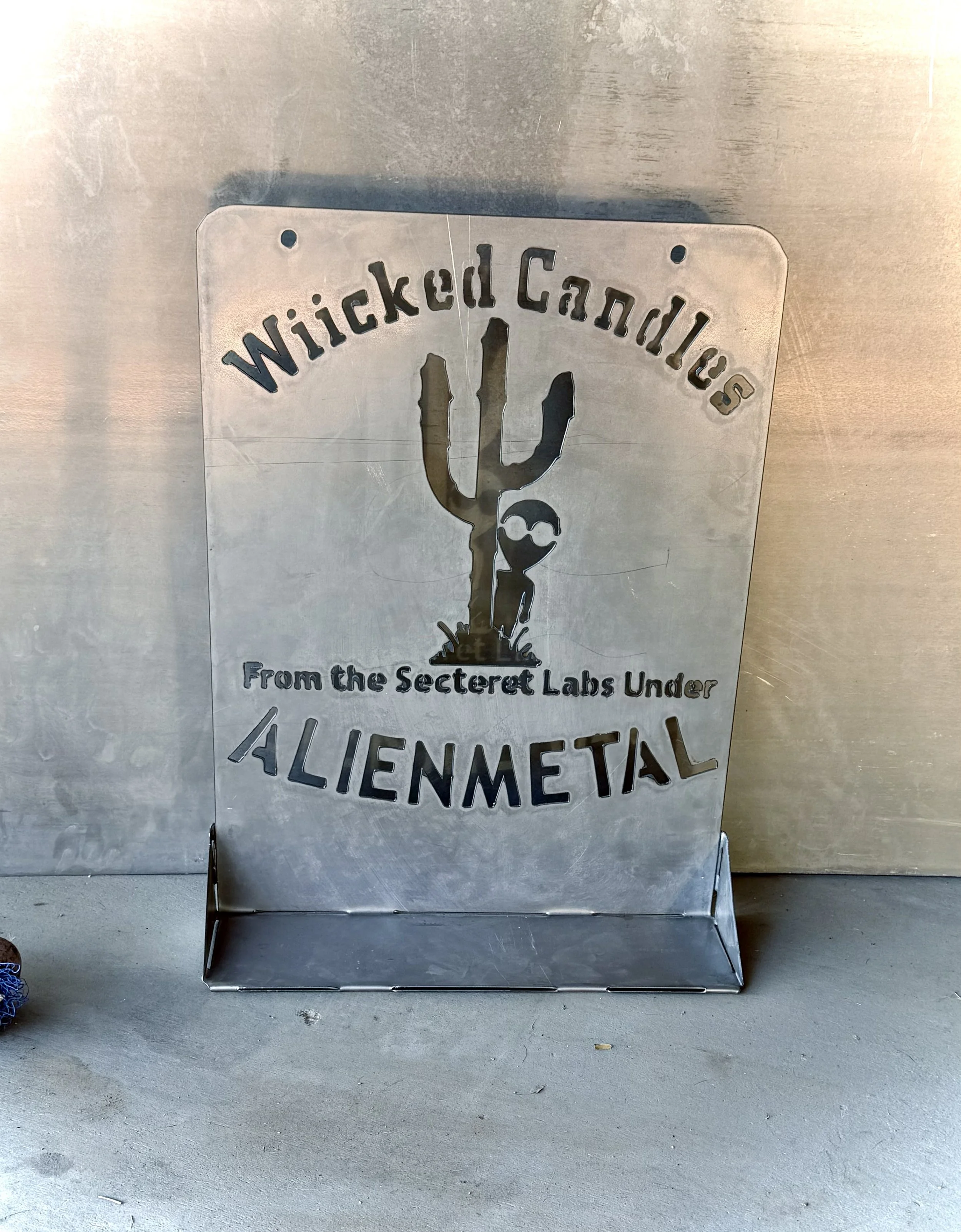 Metal sign with the words "Wicked Candles" and 