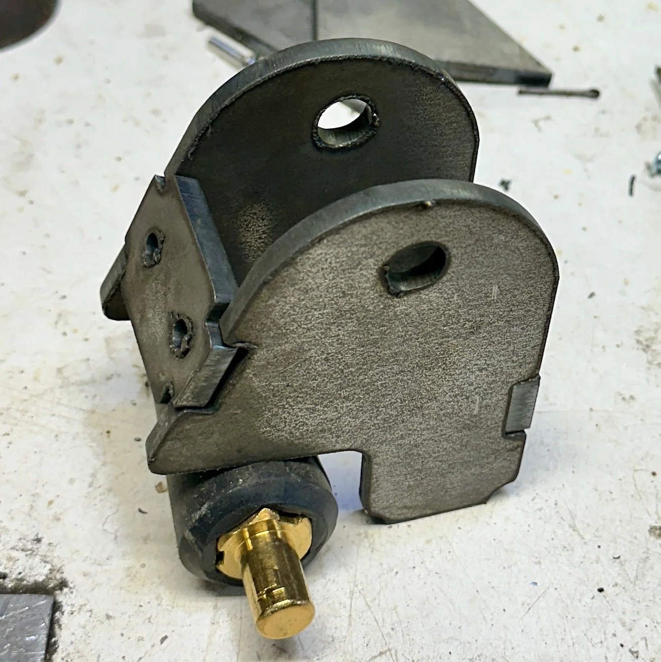 A metal mechanical component with a brass fitting and cylindrical parts on a work surface.