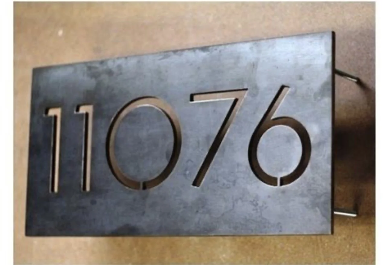 Metal house number plaque displaying '117/6'