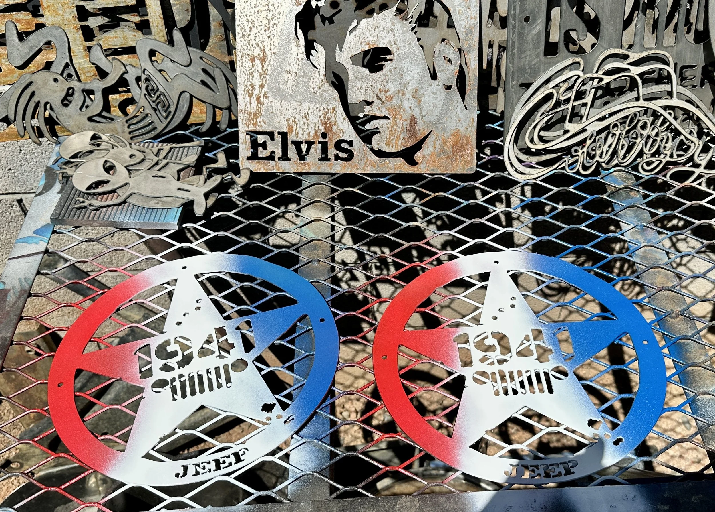 Metal artwork featuring Elvis Presley and various Rockstar symbols, displayed on a metal grid surface.