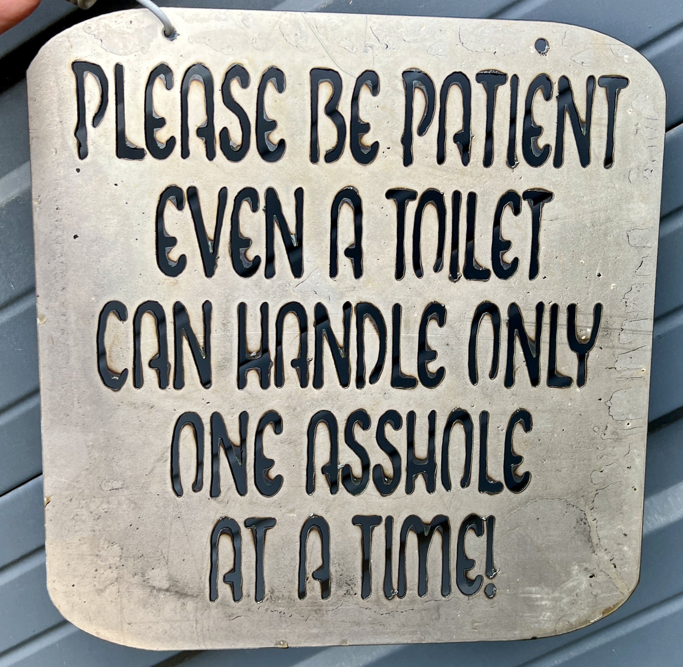 A decorative sign with cut-out letters saying: "PLEASE BE COURTEOUS, EVEN IF YOU".