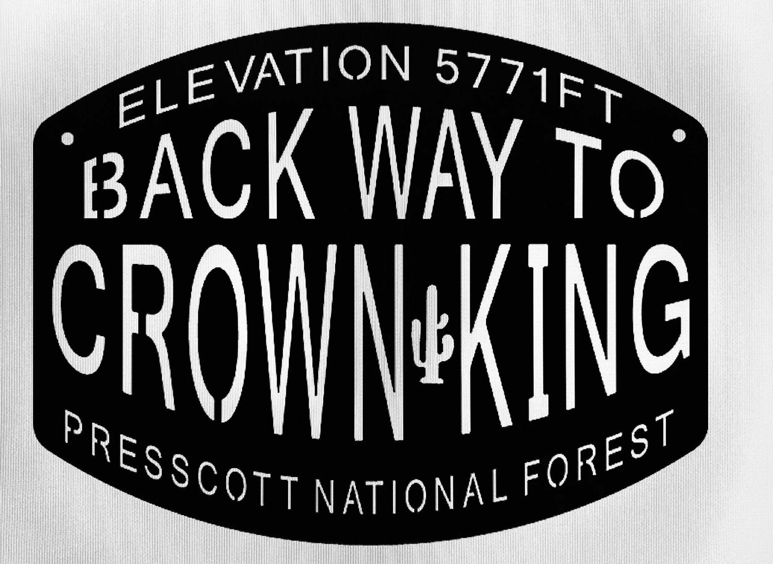 Close-up of a circular logo with the words "Elevation 5771 FT," "Back Way To," and "Crown King" visible, indicating a natural or recreational site.