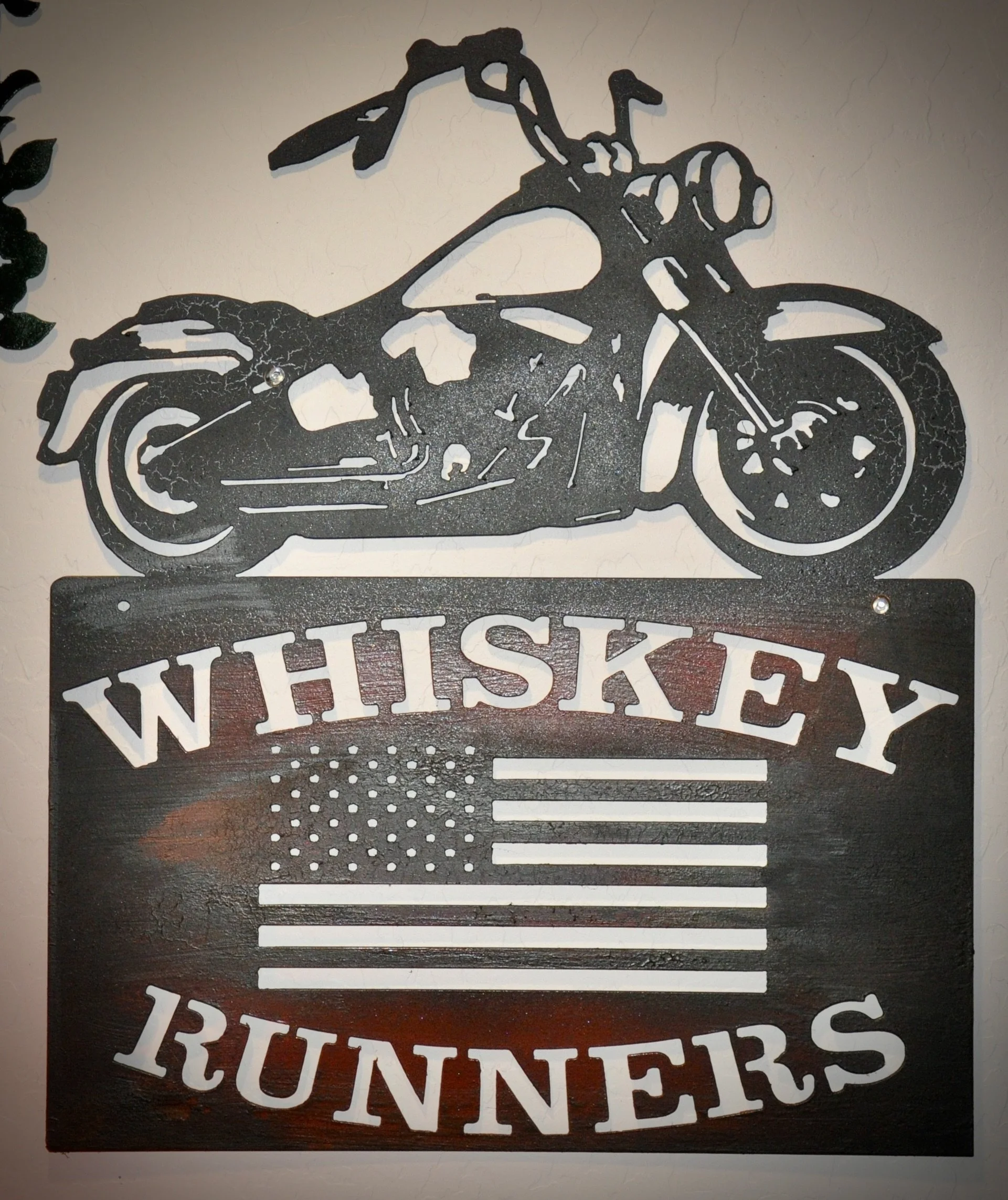 Metal wall art of a motorcycle with the word 'WHISKEY' beneath it, and an American flag pattern incorporated into the design.