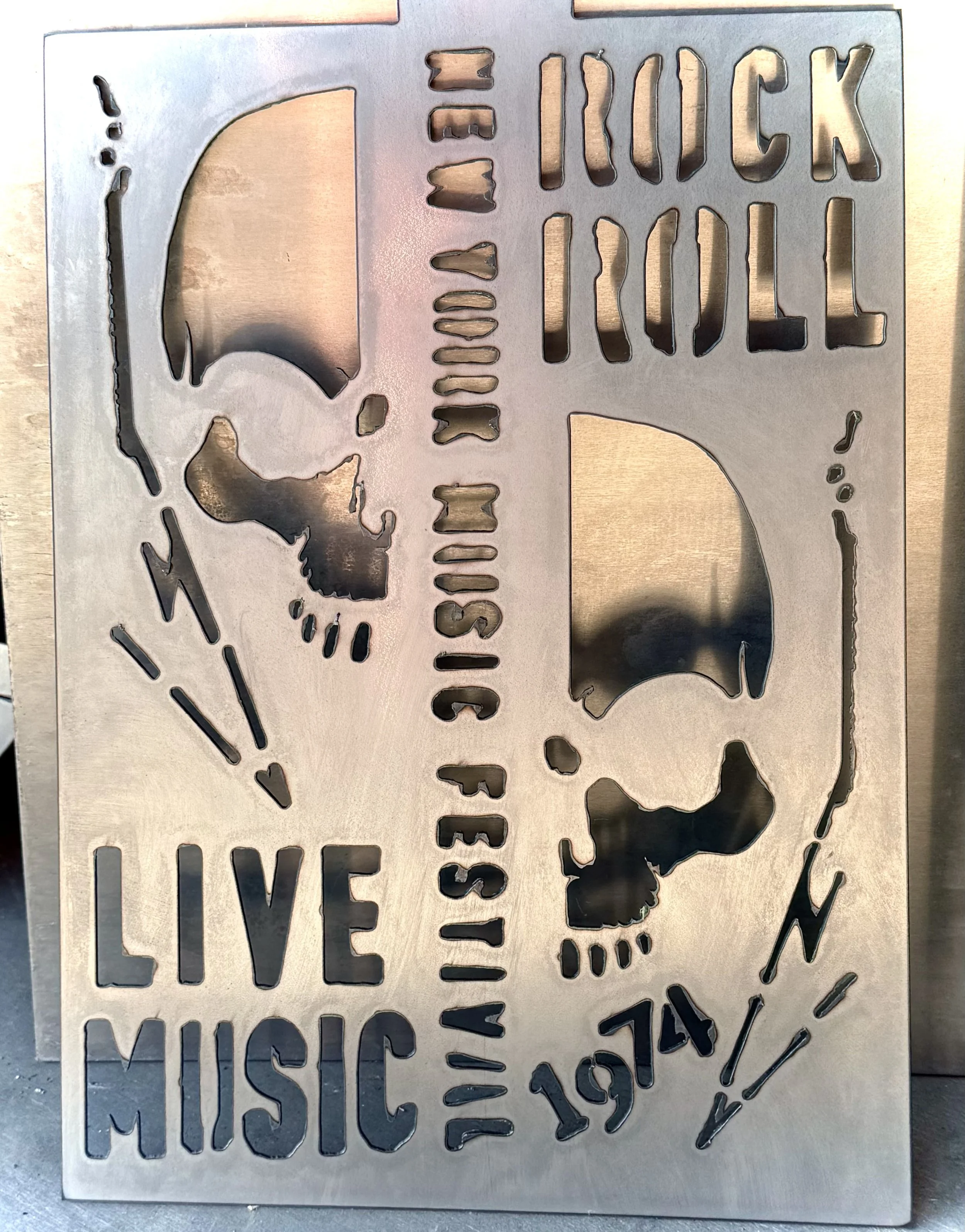 Metal stencil with the USA outline, a skull, and text reading "Trucks, Guns, & Muscles."