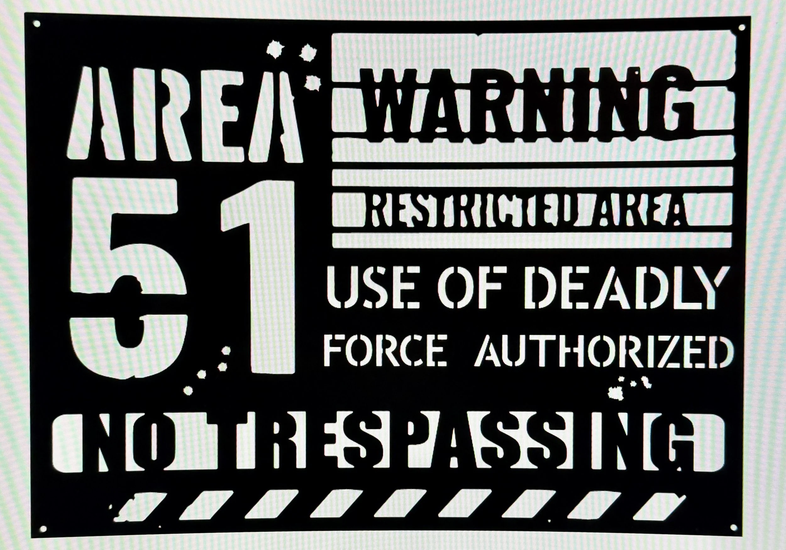 A black and white warning sign with the text 'AREA WARNING RESTRICTED AREA USE OF DEADLY FORCE AUTHORIZED'. The sign features a handgun silhouette and diagonal stripe lines.