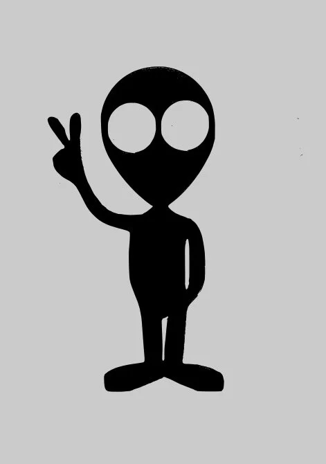 A black cartoon figure with a large, round head and two eye holes, raising its right hand in a peace sign gesture, on a gray background.