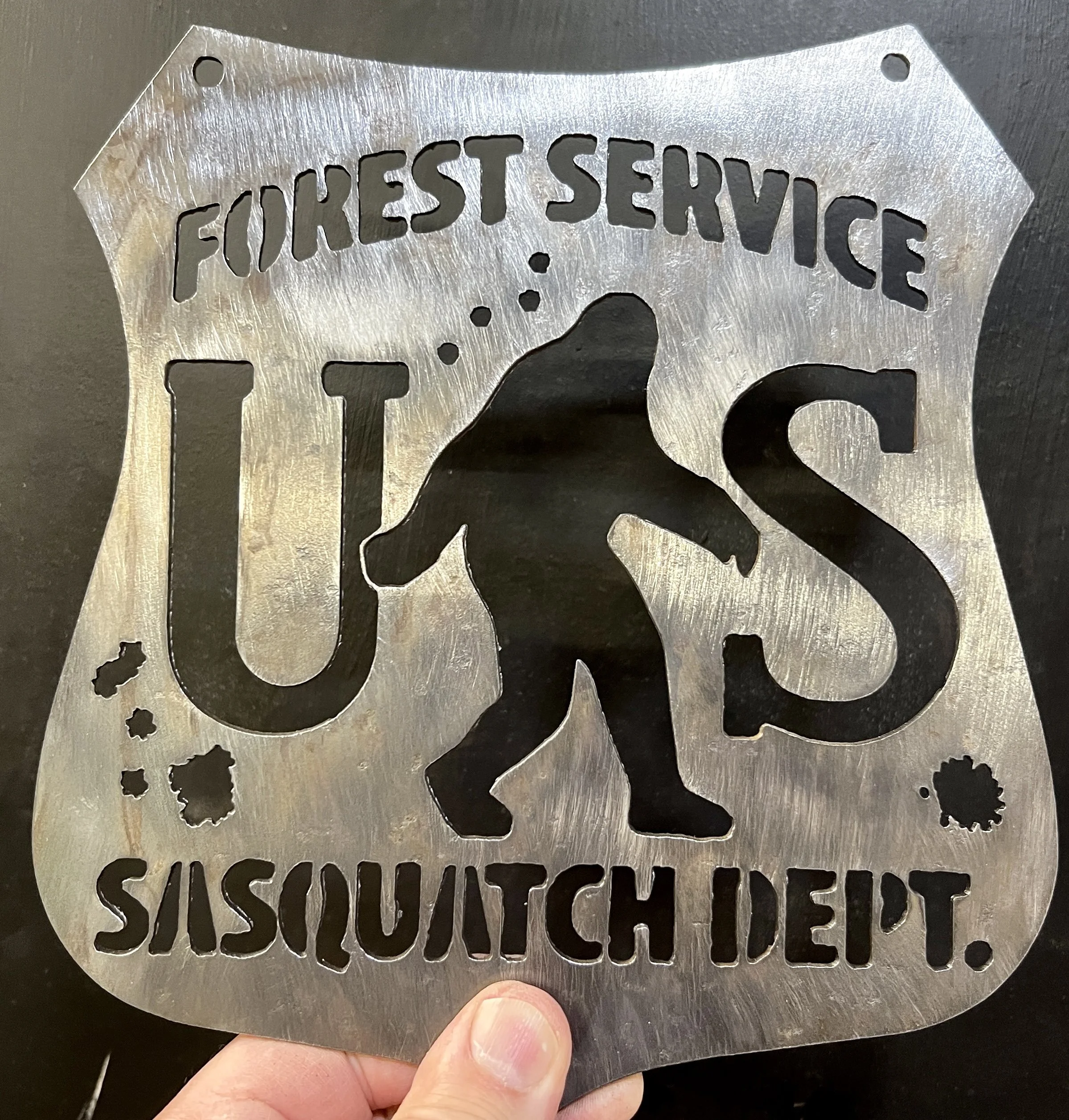 A metal cutout sign with the words "FIREEST SERVICE" and a stylized fire truck profile.