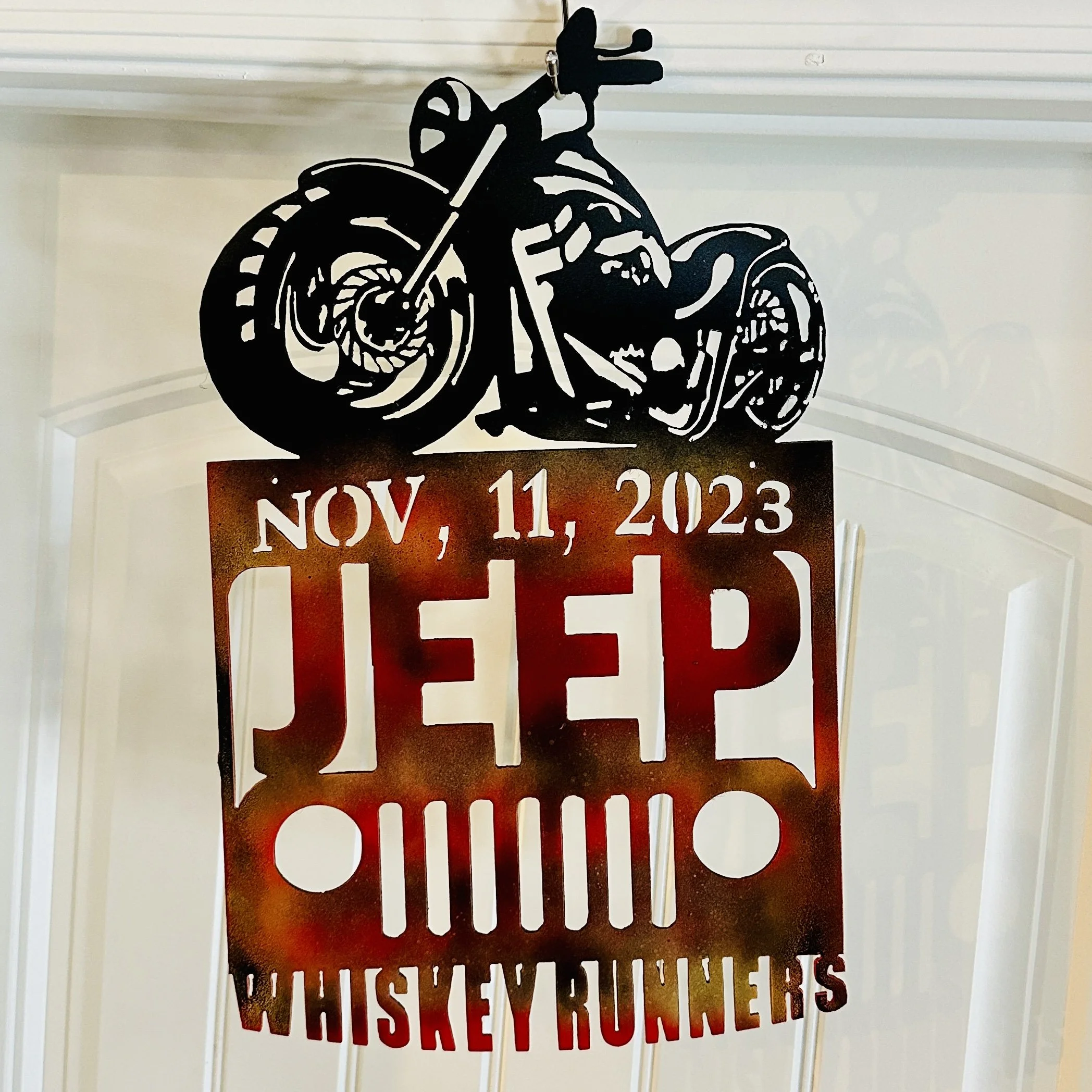 A decorative black cutout of a motorcycle with the date NOV, 11, 2023 and the words CHISEY ROUERS below it, attached to a wall.
