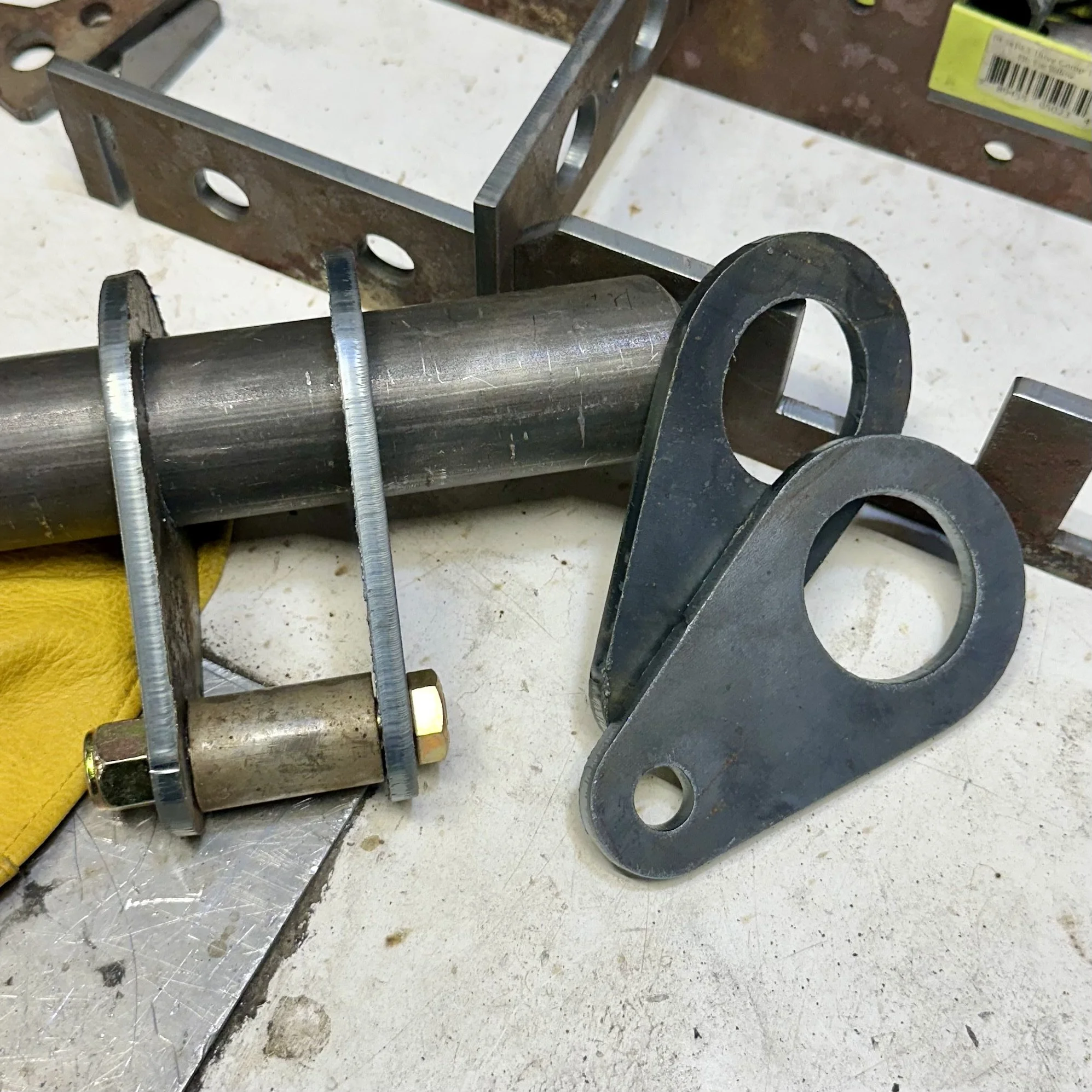 Close-up of metal machinery, showing a metal pipe mounted on a workbench with bolts and metal supports, in a workshop setting.