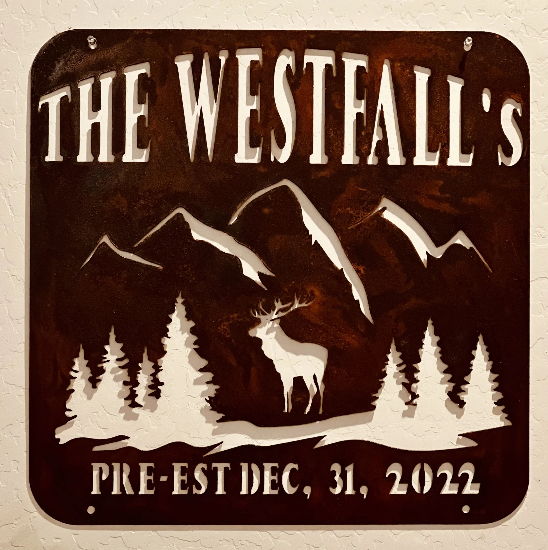 A seasonal sign with cut-out letters reading "The Wetlands Pie Est. Dec 31, 2022" on a textured white wall.