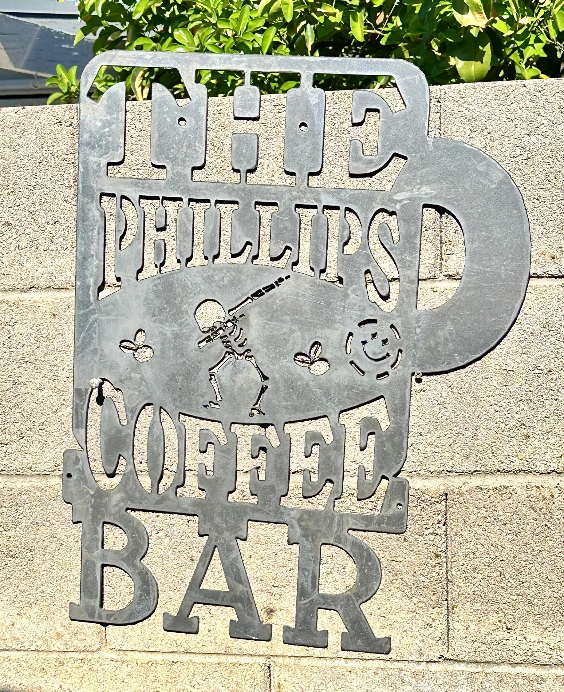 Metal cutout sign with the words 'The Philbrook Orchestra' and a musical note with a figure playing a violin.