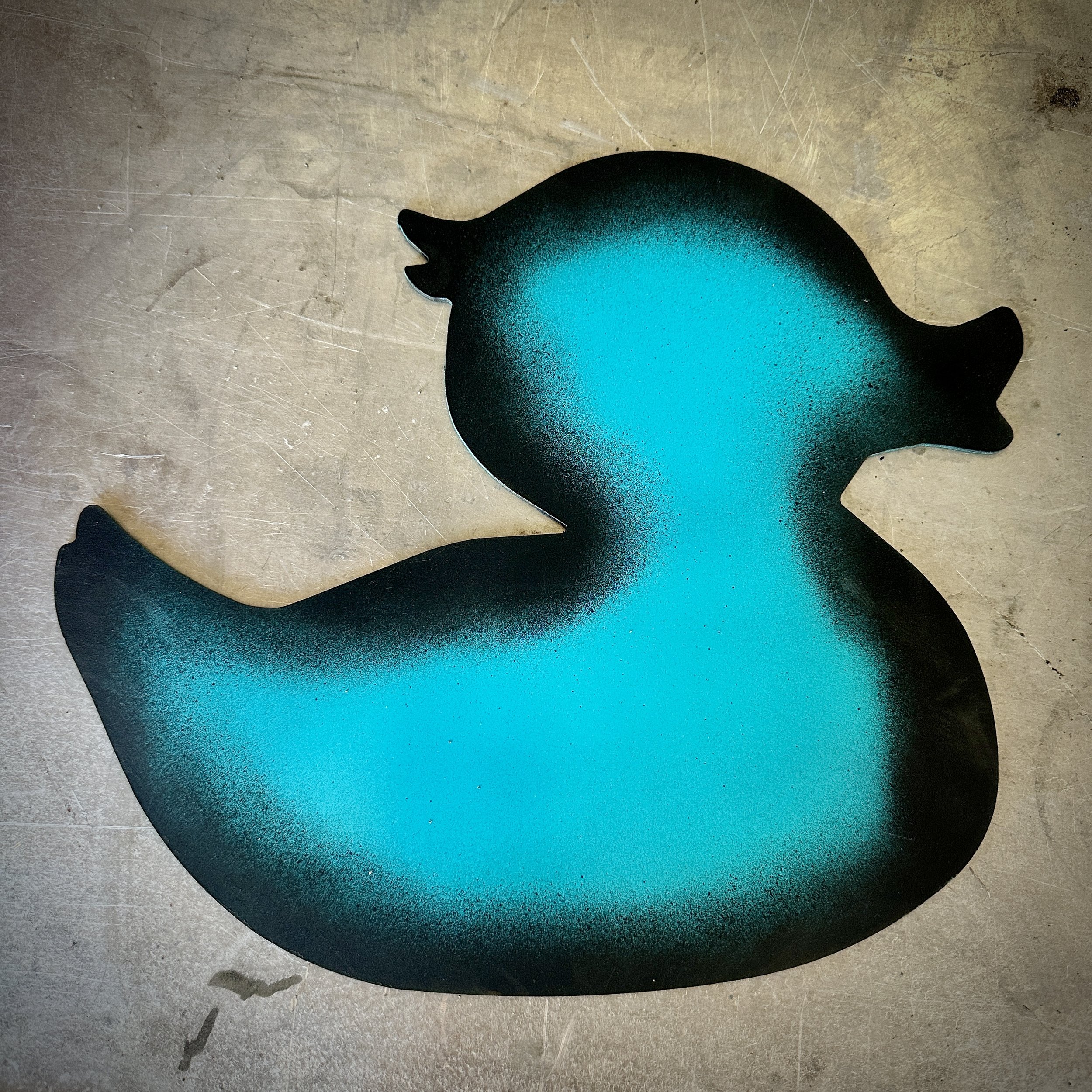 A black silhouette of a cat with a turquoise gradient on a textured light brown surface.