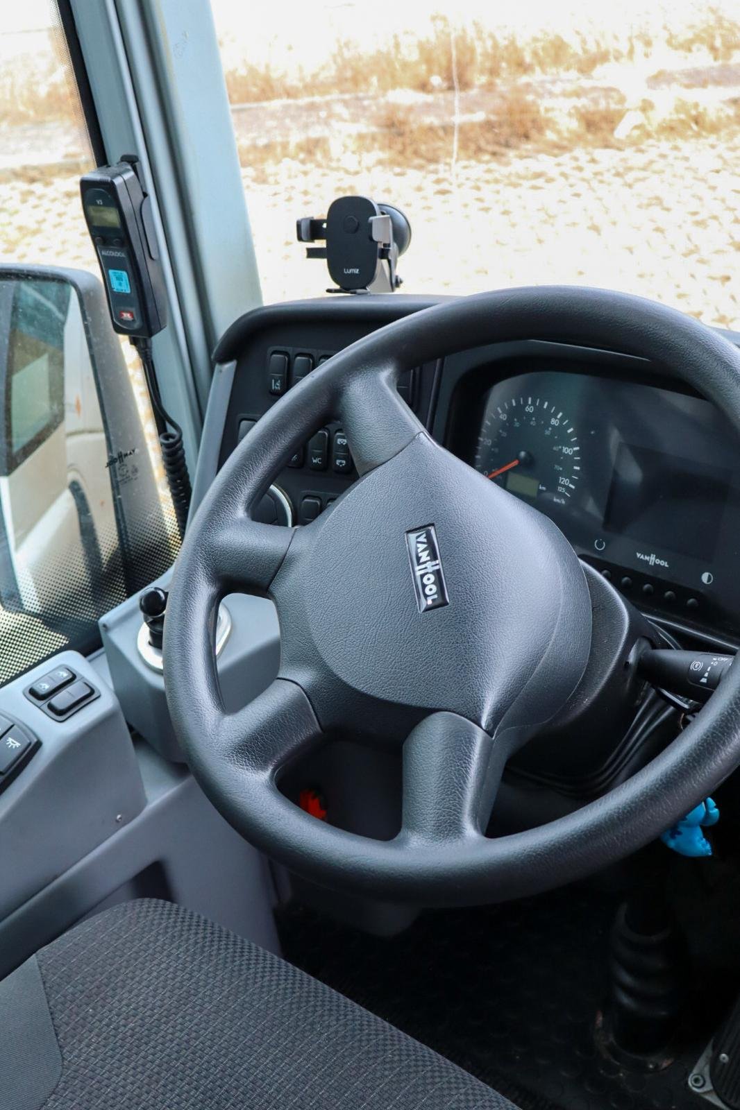 Interior de um caminhão, com volante, painel de instrumentos e dispositivos eletrônicos na cabine
