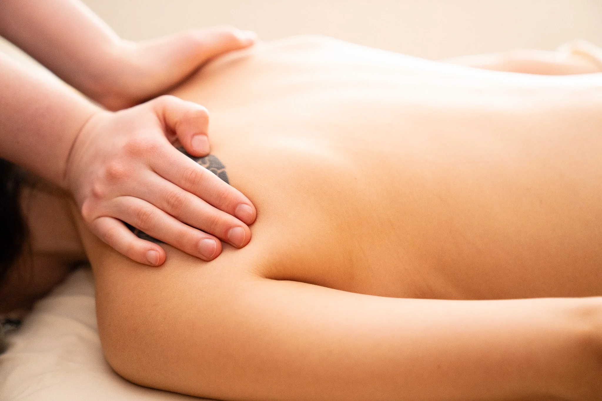 Close-up of a person's hand massaging their thigh, with a soft focus on smooth skin.