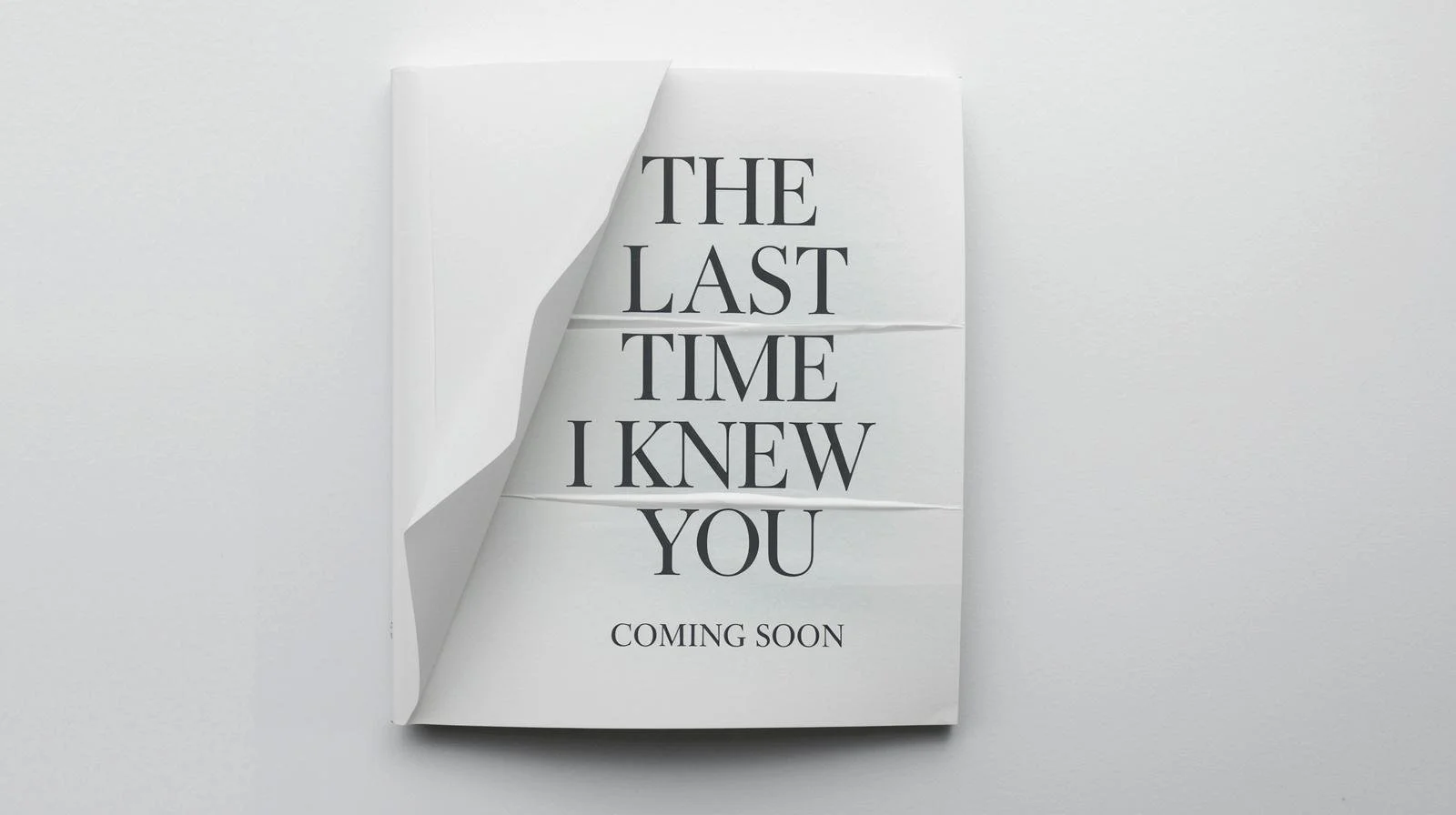 A folded white paper with black text on a plain white background. The text says, "The last time I knew you coming soon," suggesting an upcoming event or message.