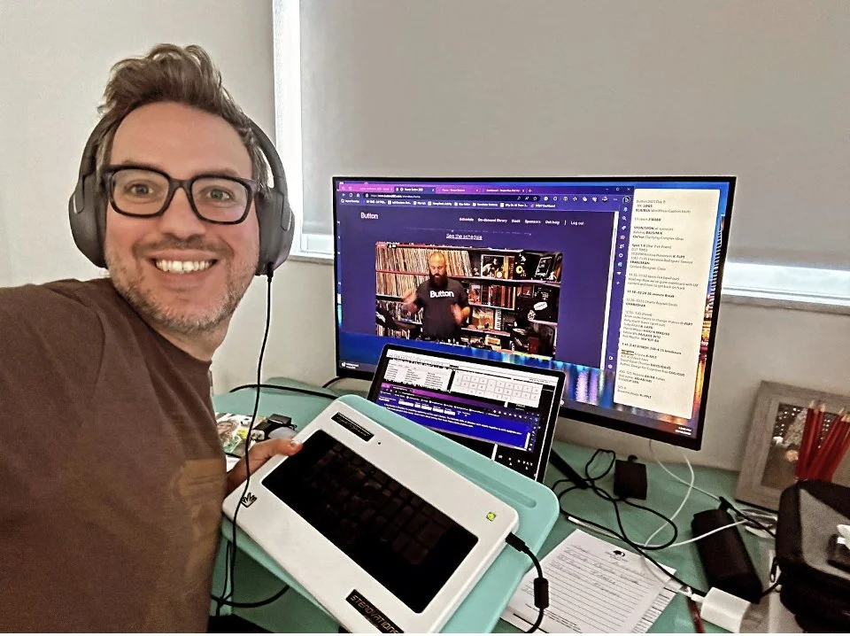 Thomas Herman captioning a live remote event from his desk, wearing headphones with a steno machine in the foreground.