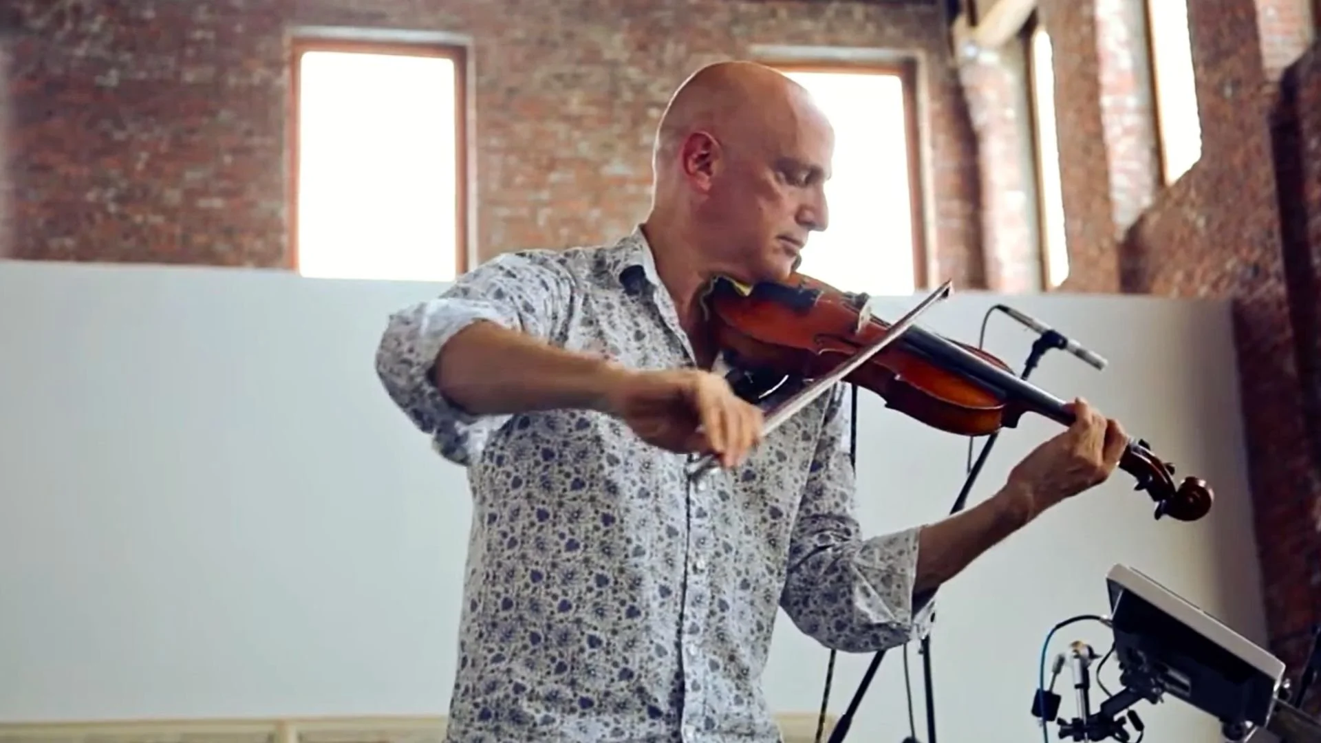 Dave Soldier playing violin during a live performance.