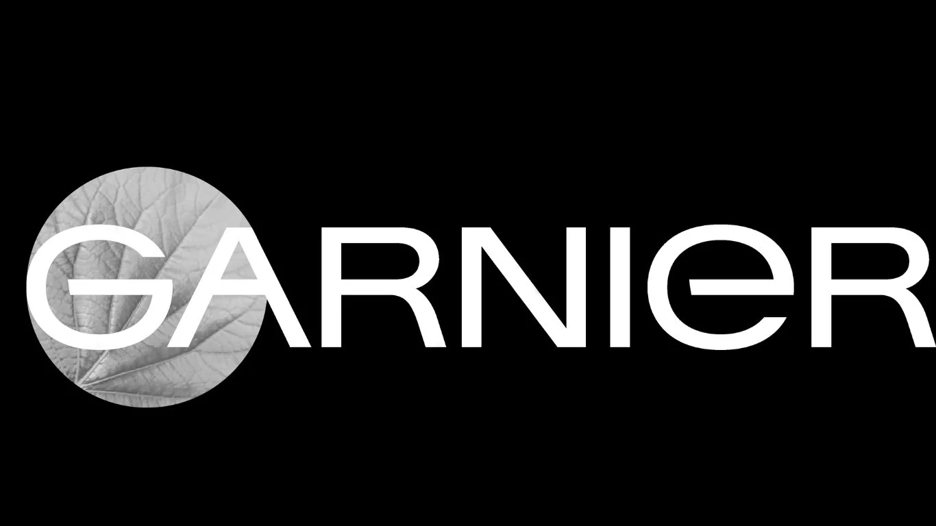 Garnier logo with a circular leaf image in black and white on the left side and the word 'GARNIER' in uppercase white letters on a black background.