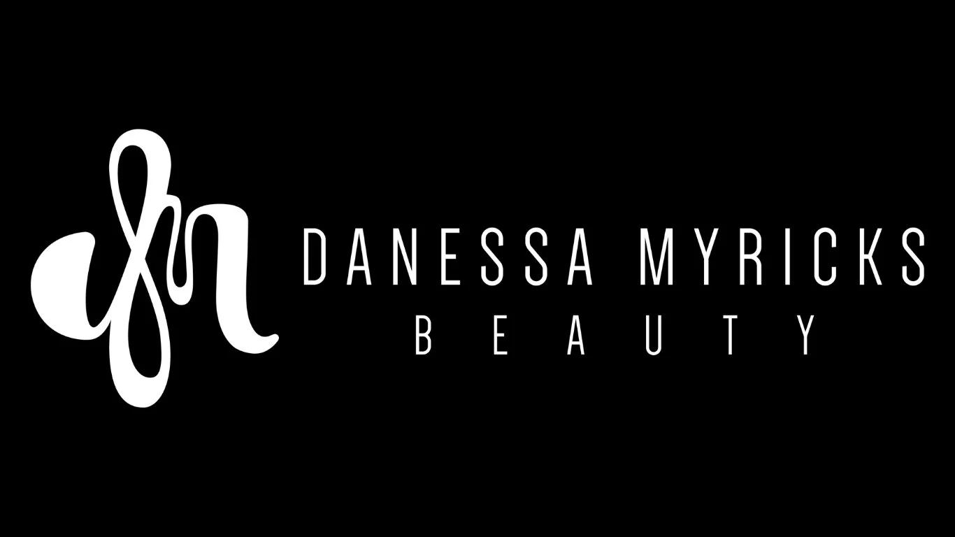 Logo for Danessa Myricks Beauty with the initials dmb in cursive on a black background.