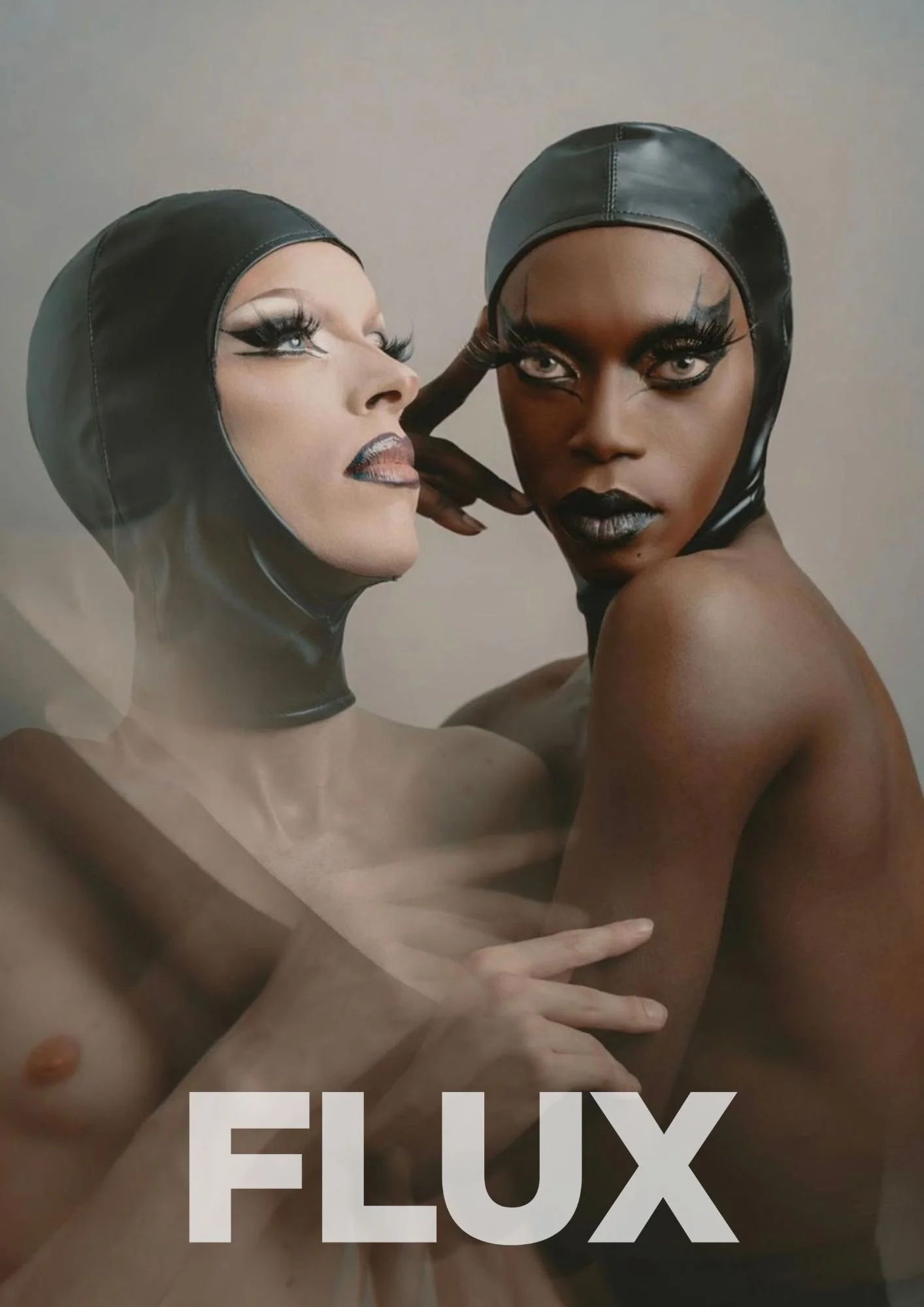 Two women with dramatic makeup and black leather head coverings, posing closely for a photo. One woman has light skin and the other has dark skin, both with striking eye makeup and long lashes.