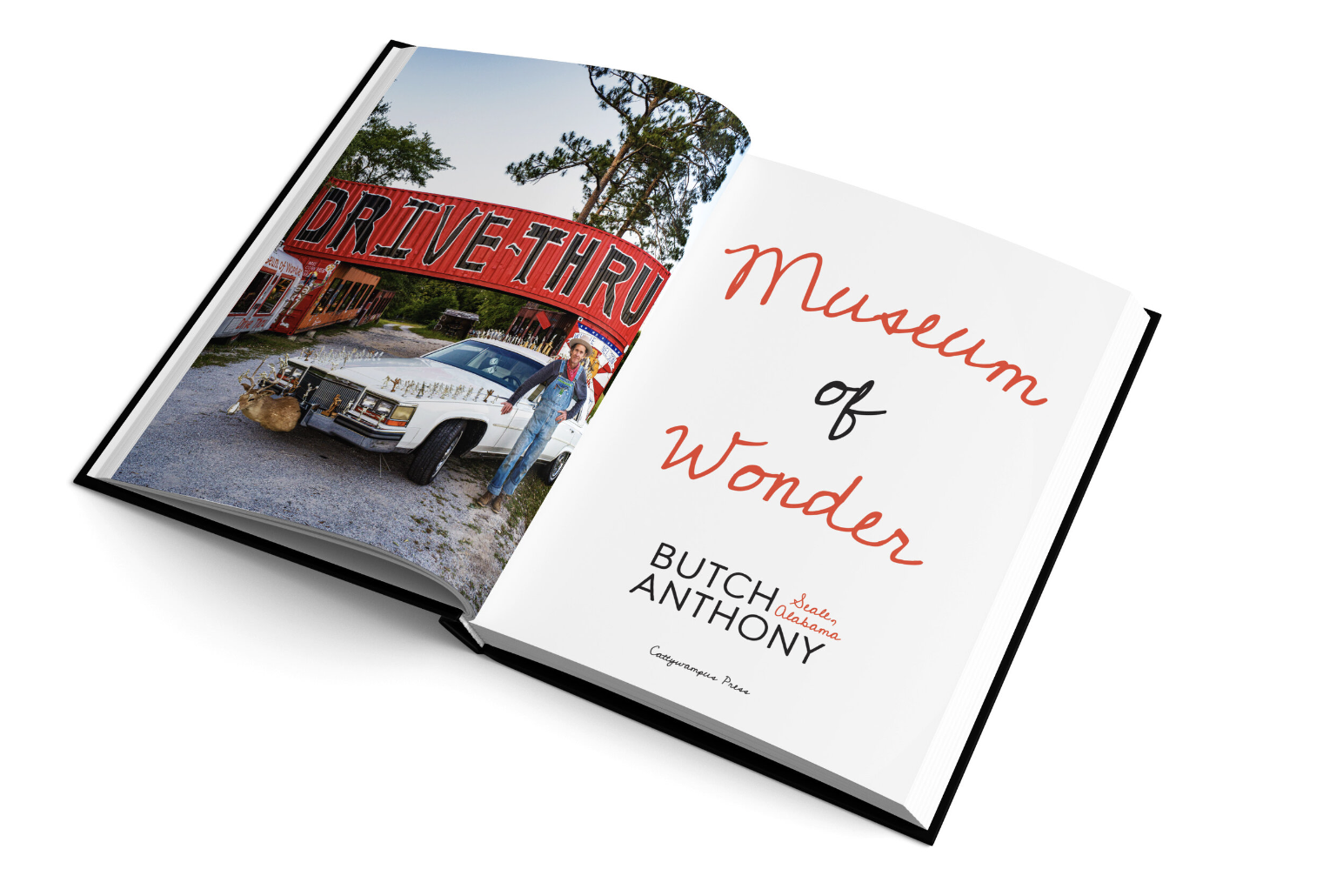 Open book featuring a photo on the left page of a woman standing next to a vintage white car decorated with antlers in front of a red drive-thru sign reading "DRIVE-THRU." The right page has the title "Movement of Wonder" and the author's name, Butch Anthony, with a location note, Saula, Alabama.