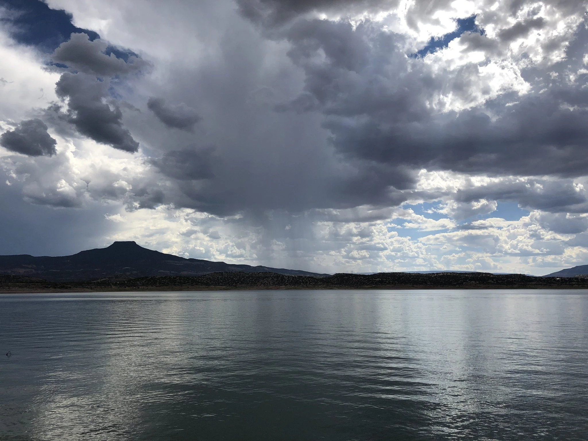 Calm lake with clouds reflected on the water, representing reflection and emotional grounding in therapy.