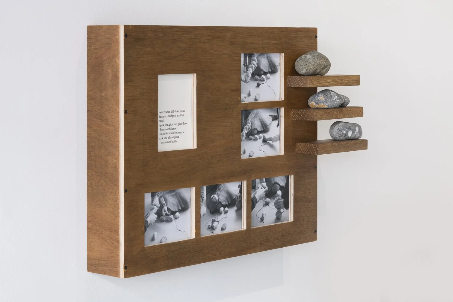 Wooden display with printed text, black and white photographs of rocks, and real rocks on small wooden shelves