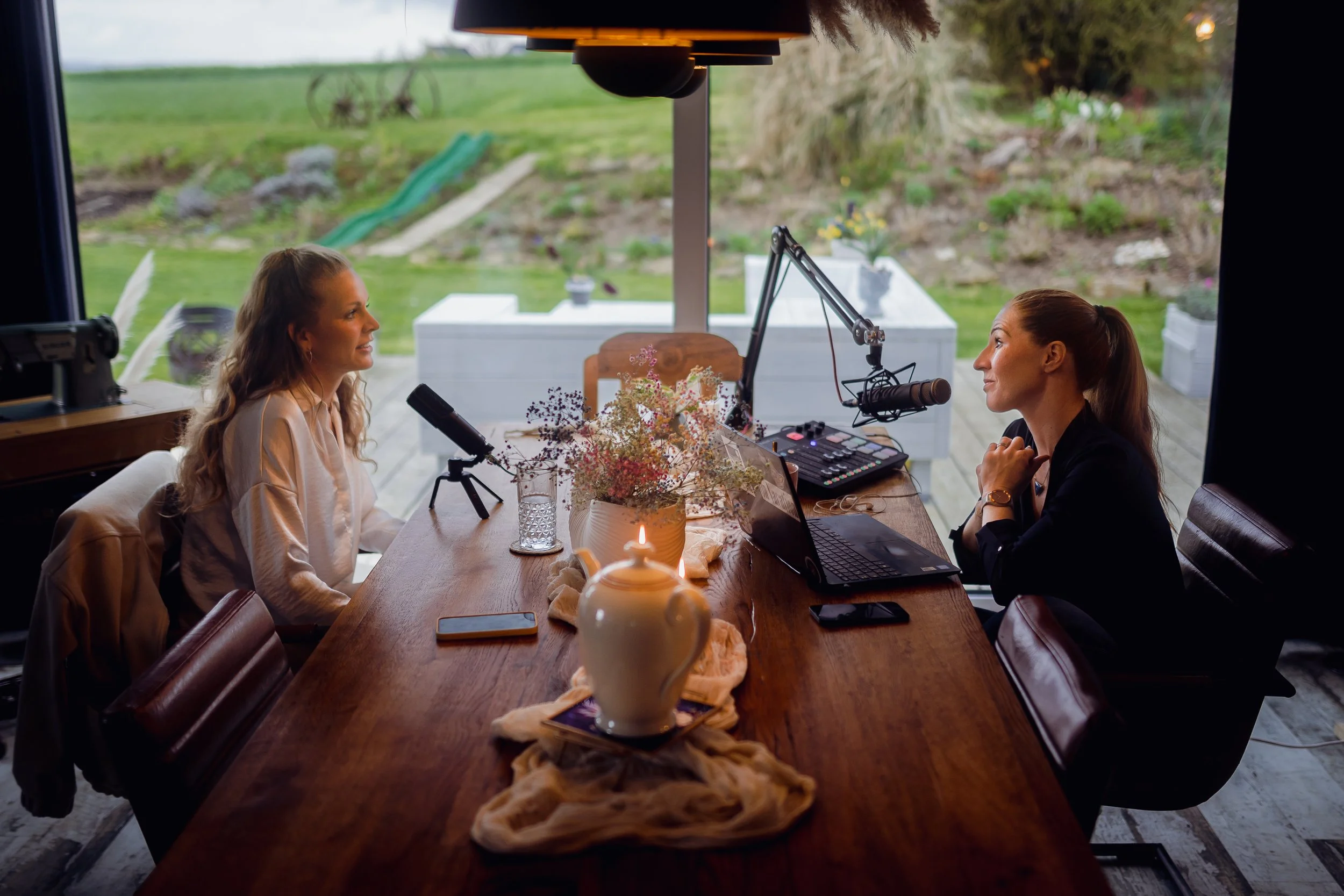 Alexandra Dersch, Moderatorin, Kommentatorin, ZDF, Leichtathletik, Curling, Para Ski Alpin, Skispringen, Sportstudio, TV-Kommentar, Livestream, Zwei Frauen sitzen sich gegenüber an einem Holztisch mit Mikrofonen und Laptop, Podcast, Christina Honsel,