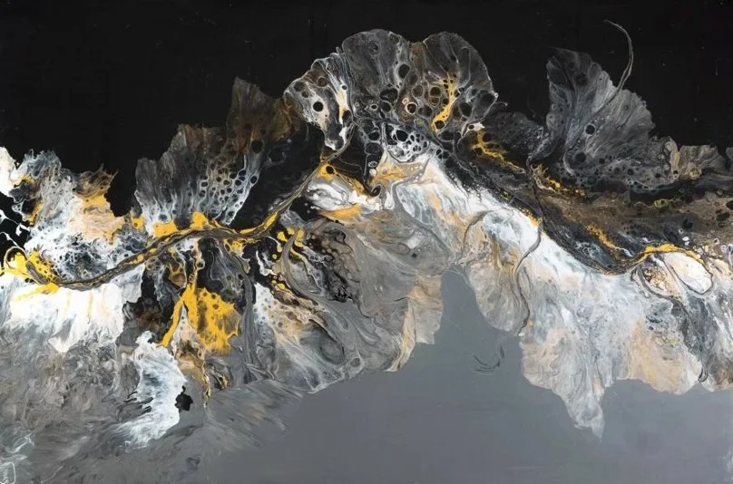 Abstract black, gold, white, and gray paint flowing together in a fluid pattern.