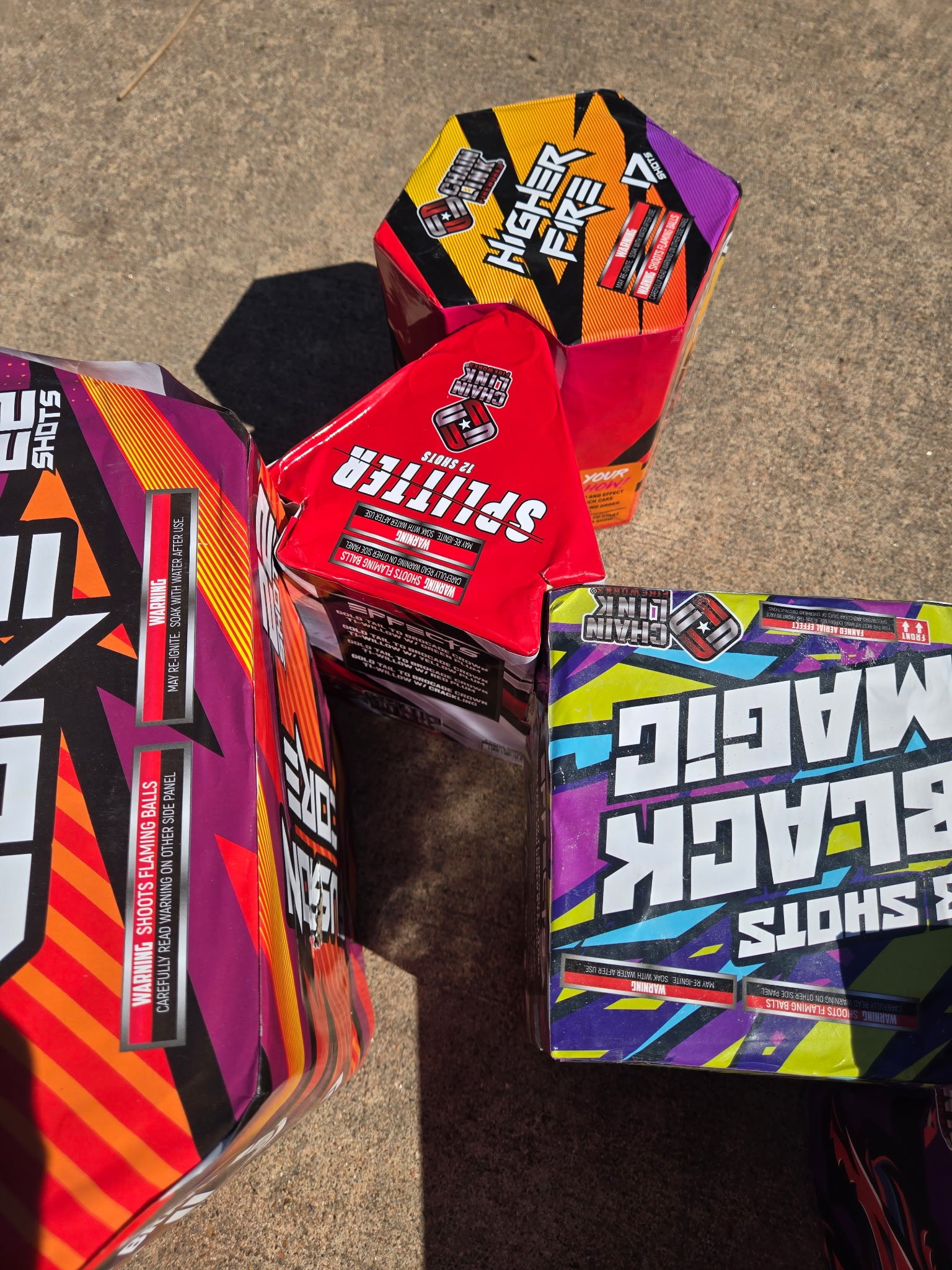 Colorful fireworks boxes on concrete ground.