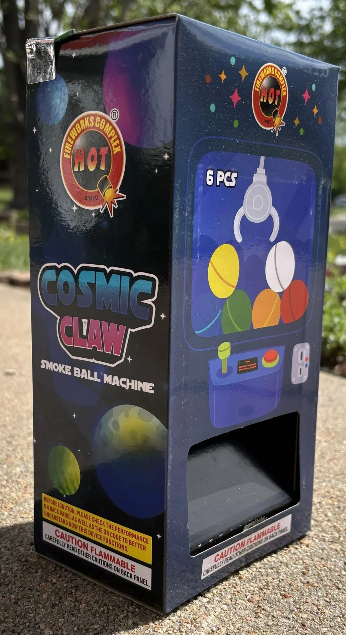 A cosmic-themed smoke ball machine with a space and arcade game design, labeled "Cosmic Claw," containing 6 pcs of colorful spherical smoke balls.