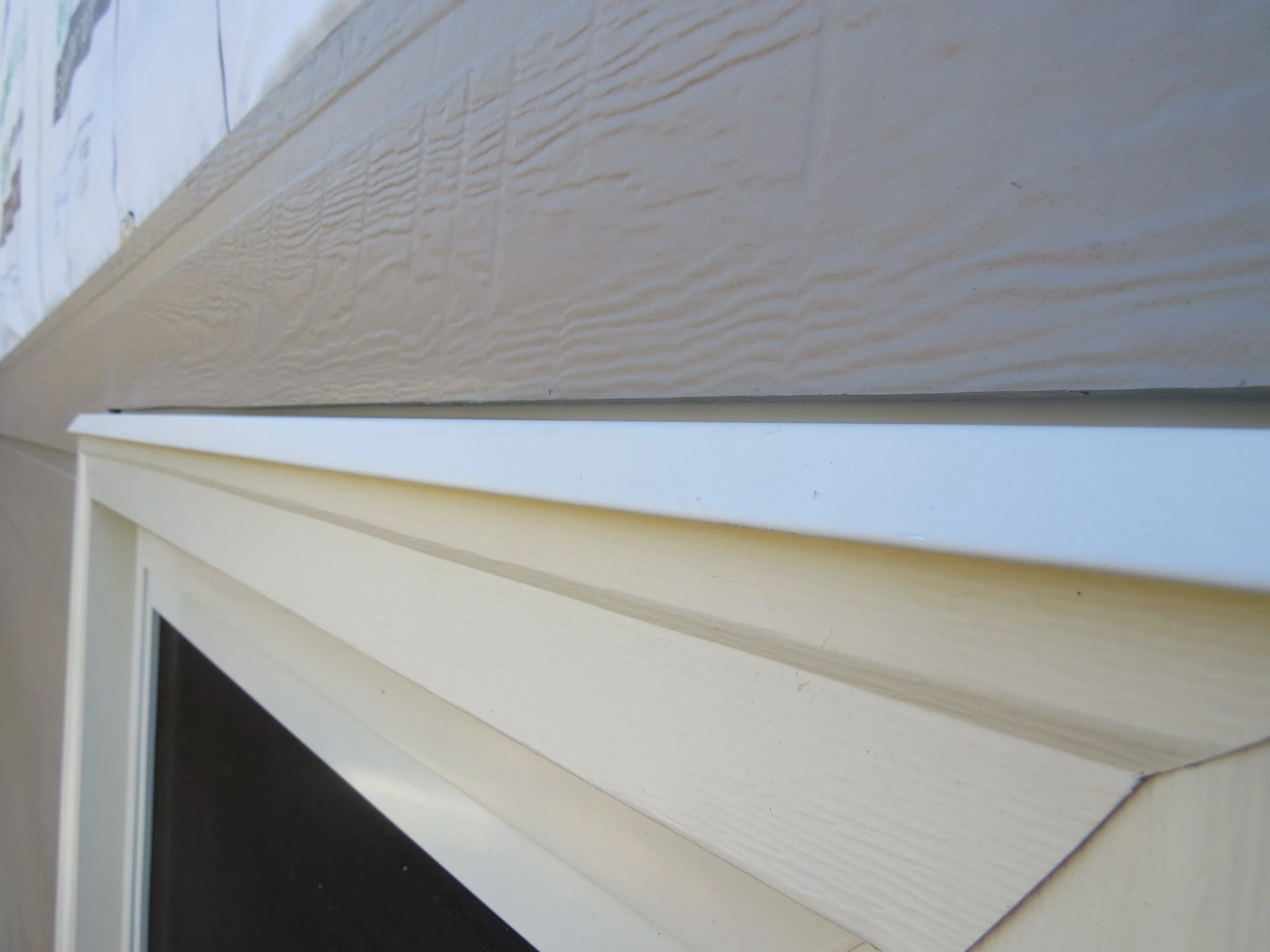 Fiber cement siding installation with head flashing above window trim to promote drainage and long-term moisture protection.