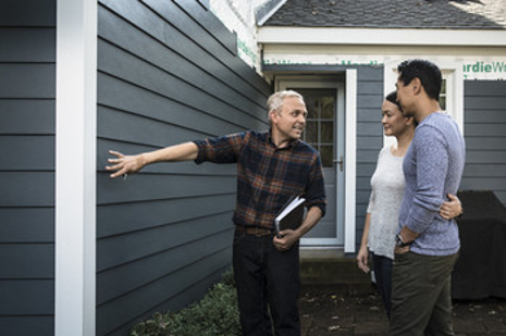 Homeowners learning about fiber cement siding systems, exterior remodeling best practices, and building science during a residential consultation.
