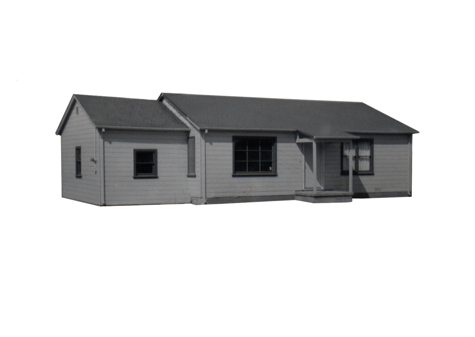Front view of a small, single-story house with light-colored horizontal siding, a dark roof, and multiple windows.