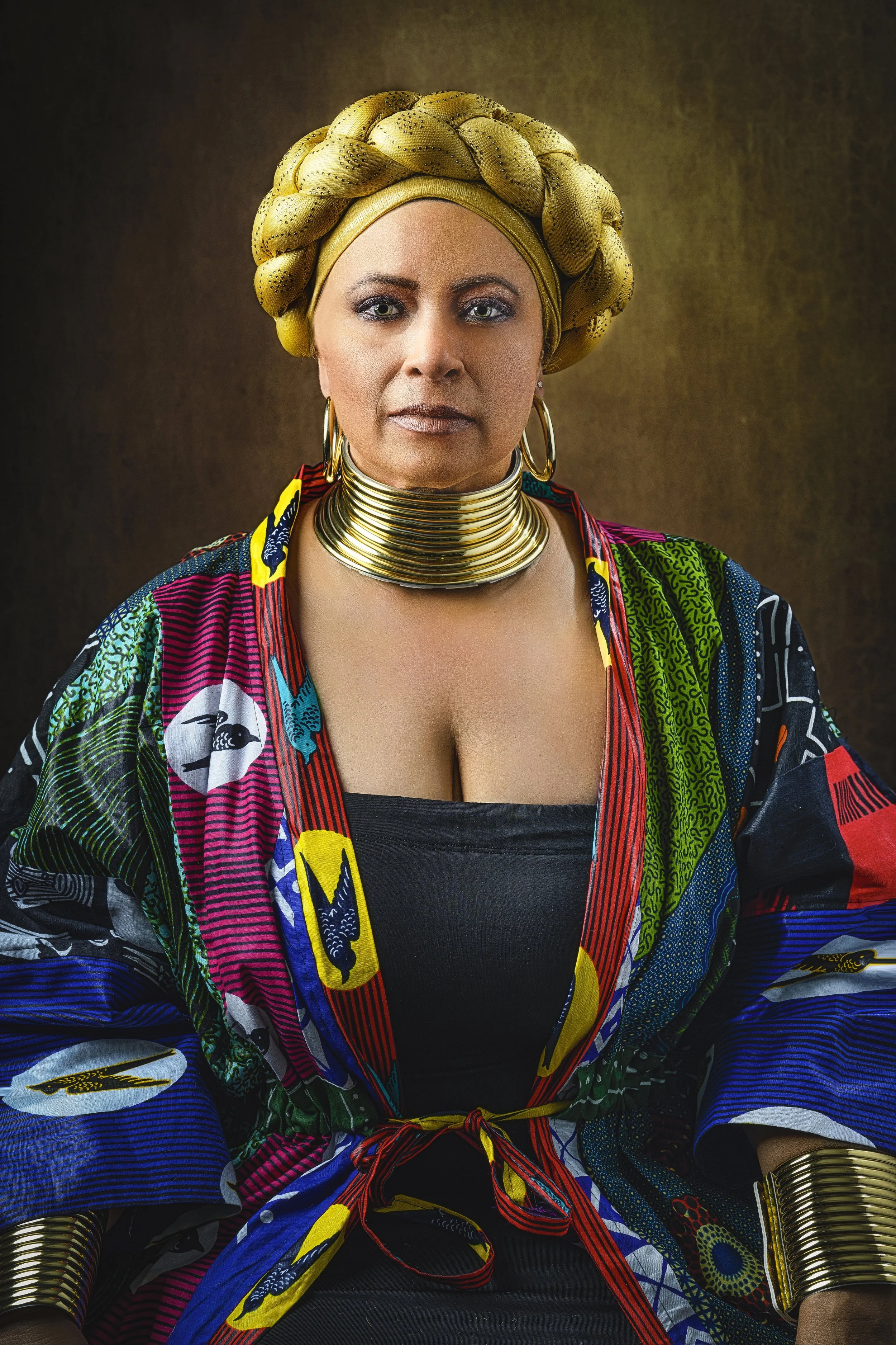 Fine art portrait featuring colorful wardrobe, gold headwrap, and dramatic painterly lighting.