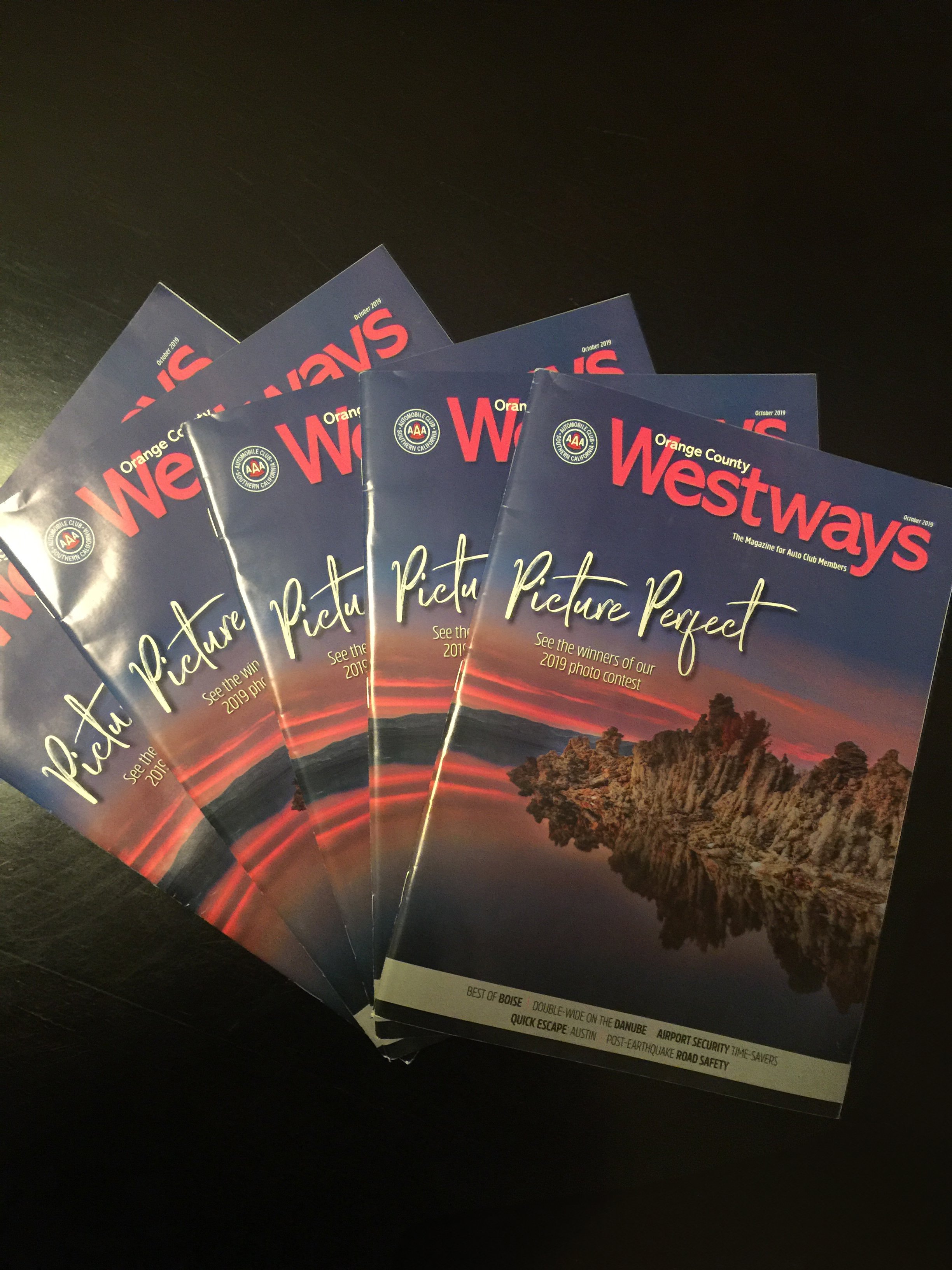 Multiple copies of Westways magazine featuring a sunset landscape with rock formations and trees.