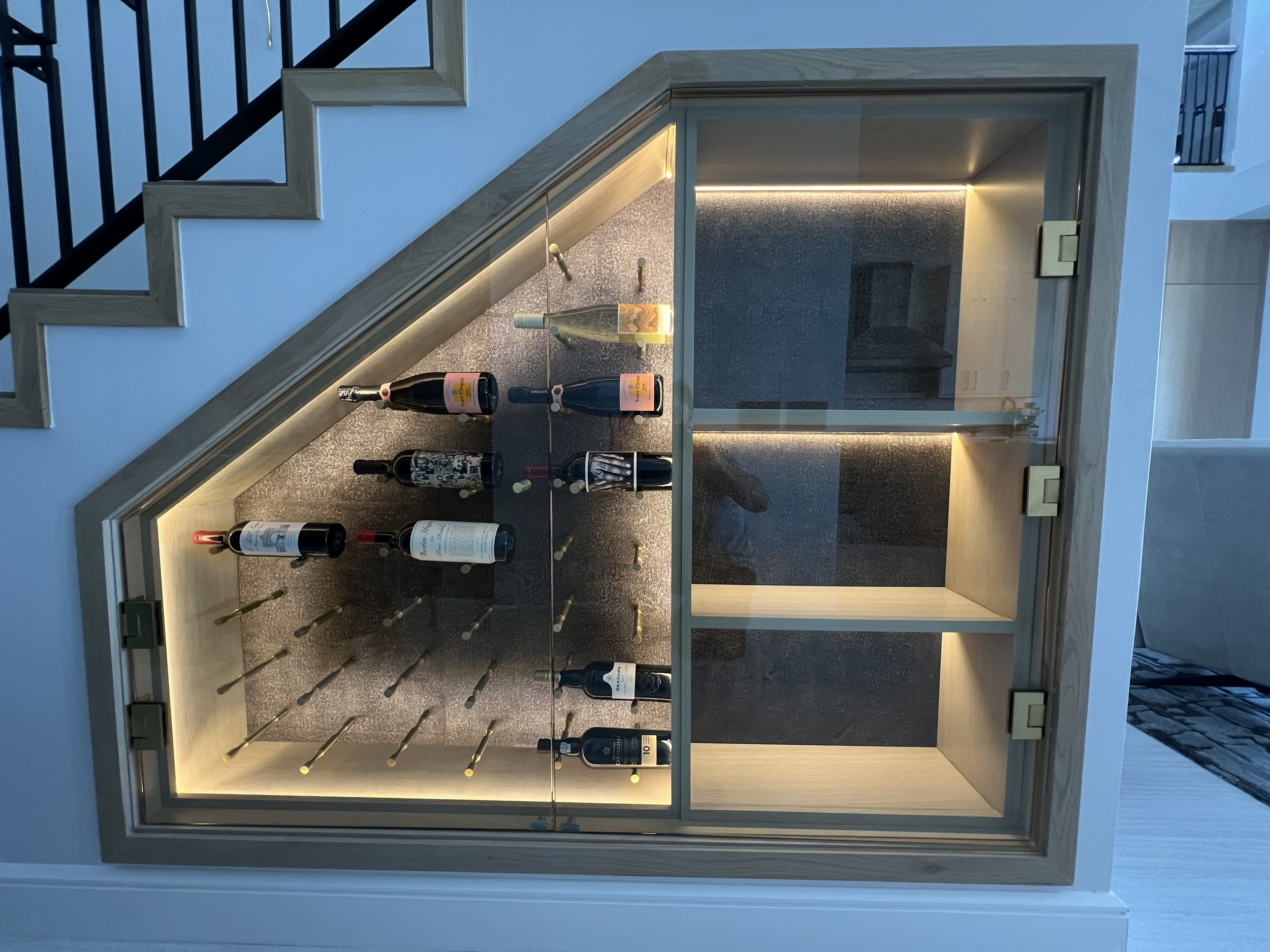 A wine rack utilizing an under-stair space.