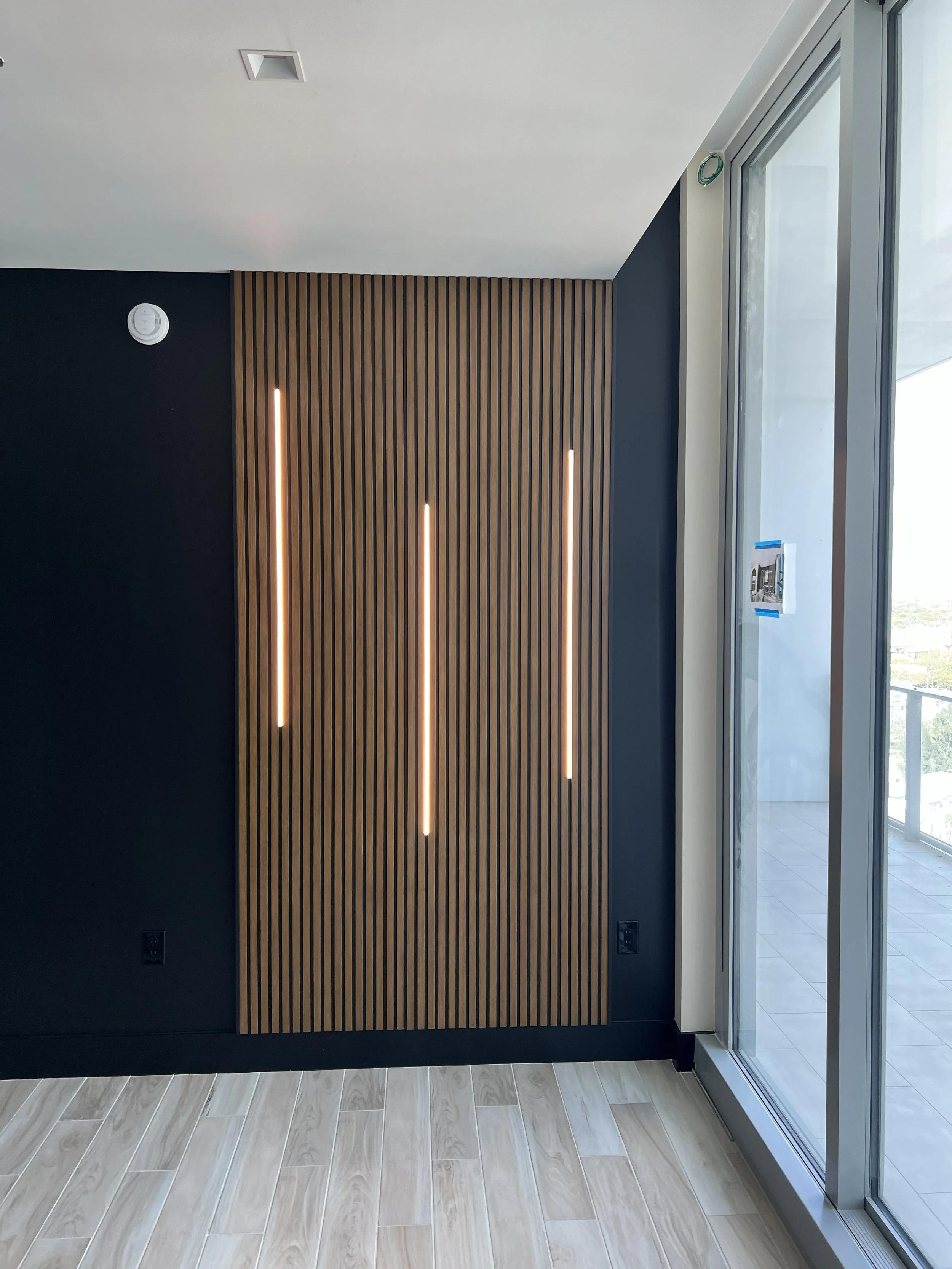 Stained white oak slat wall with integrated lighting.
